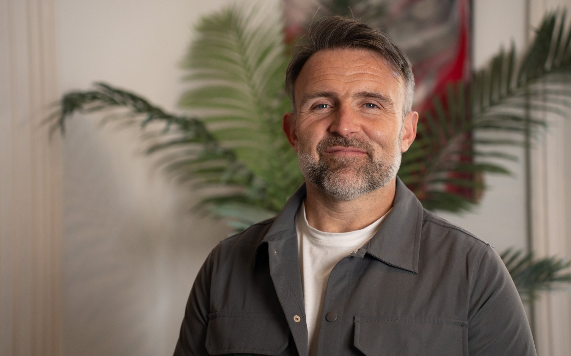 Dave Radley smiling, in a grey overshirt